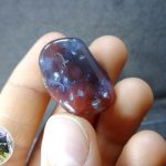 Полированная галтель красноватого халцедона. Есть природные неровности. Месторождение: Южный Урал